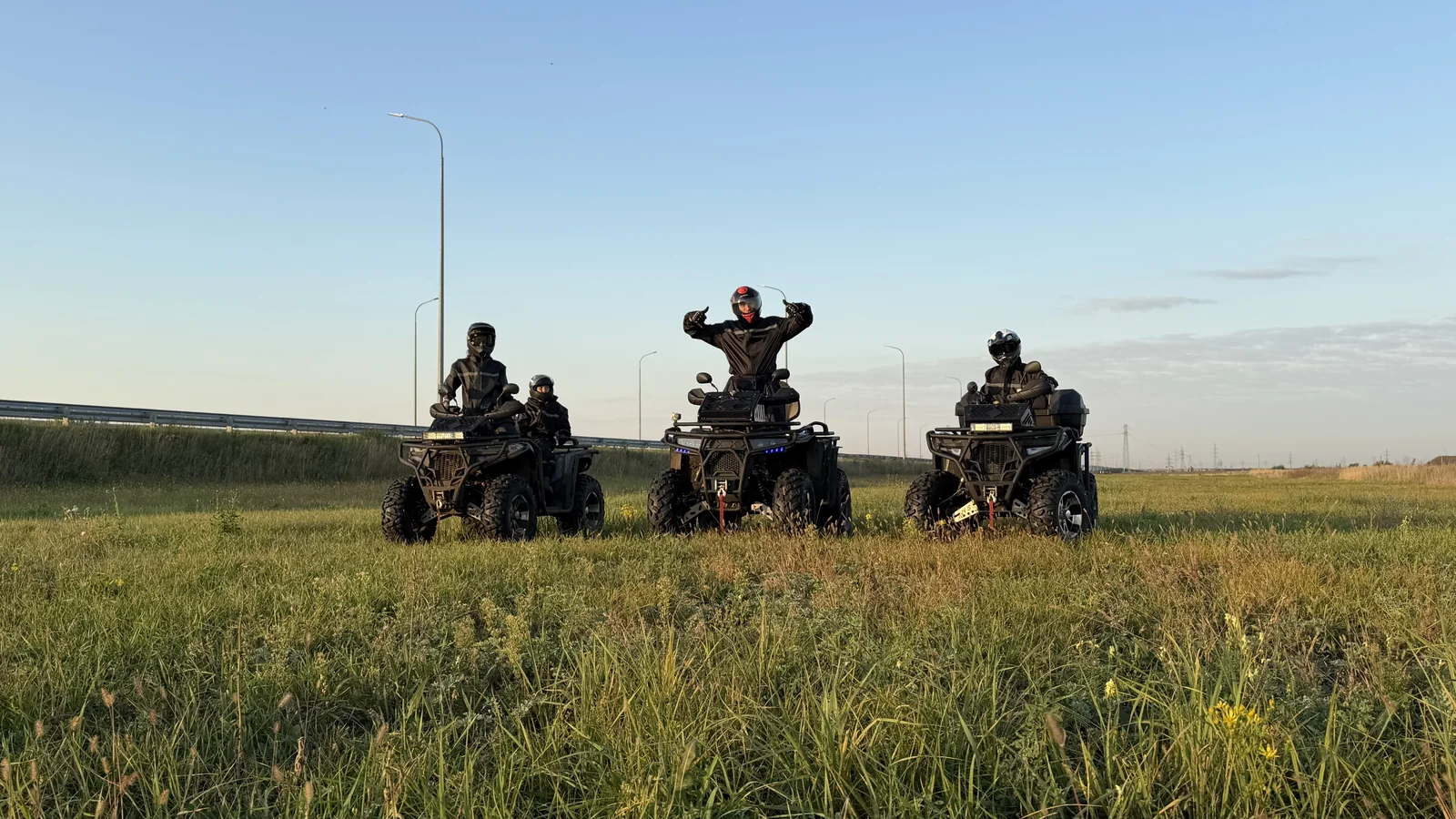 Три квадроцикла с участниками поездки на открытом поле